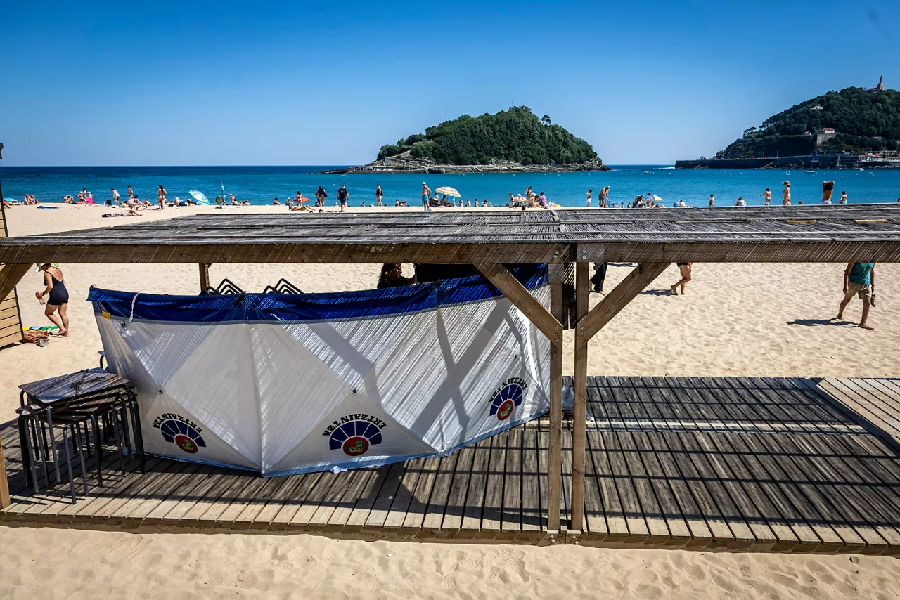 SAN SEBASTIÁN, 26/05/2026.- Un biombo de la Ertzaintza protege el cuerpo de un hombre que ha fallecido este martes tras ser rescatado del agua en la playa donostiarra de Ondarreta. Los servicios de emergencias han recibido un aviso sobre las 10.40 horas, tras lo que varias ambulancias se han desplazado al lugar. EFE/Javier Etxezarreta
