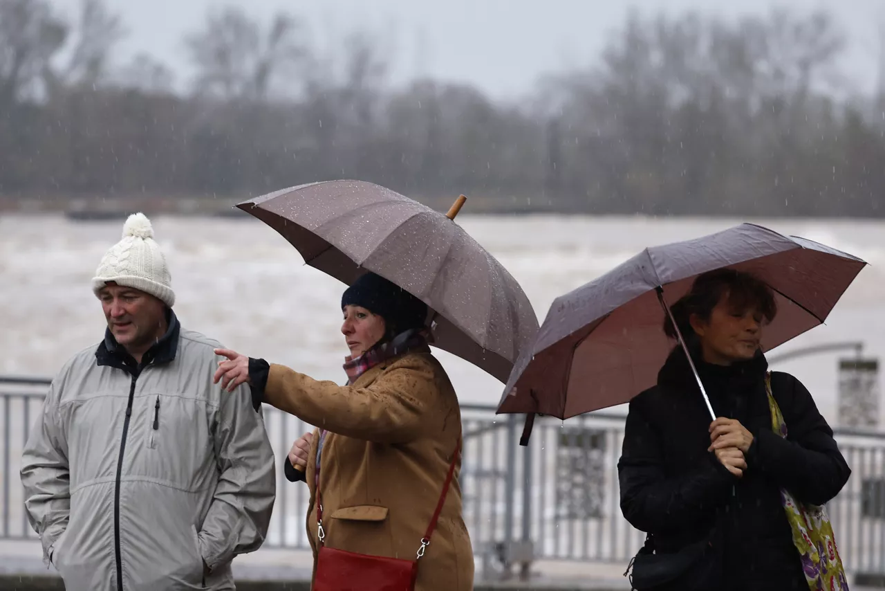 Agde (France), 23/12/2025.- People walk next to the Herault river in Agde, Southern France, 23 December 2025. Due to heavy rain, Meteo-France issued a red warning for flooding. (Francia) EFE/EPA/Guillaume Horcajuelo

