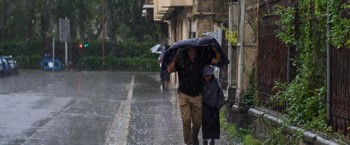 VITORIA, 11/07/20.- Dos personas se refugian de la lluvia y el granizo caido hoy viernes en Vitoria por el paso de la DANA por el norte del pais. EFE/ADRIAN RUIZ HIERRO
