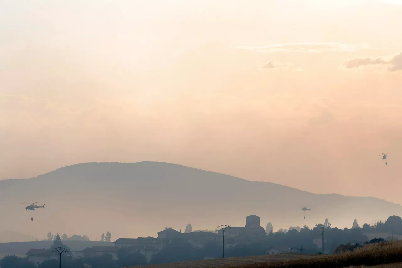 EZCABARTE (NAVARRA), 25/06/2026.- Bomberos trabajan este jueves en la extinción de un incendio que se ha declarado en Ezcabarte, en Maquirriain, en un campo situado en la falda del monte y que se ha propagado a una zona de pinar. SOS Navarra, ha indicado que no hay personas afectadas y que el incendio ha comenzado en la carretera NA-4210, en el punto kilométrico 2,4. Para hacer frente al incendio se han movilizado bomberos de Cordovilla, del parque de Trinitarios, de Estella, de Lodosa, de Sangüesa y de Tudela. Están interviniendo en el lugar en estos momentos. También participan en el dispositivo de extinción la Brigada Helitransportada de Incendios Forestales, dos helicópteros, guardias forestales de Medio Ambiente y agentes de la Policía Foral. EFE/ Jesús Diges

