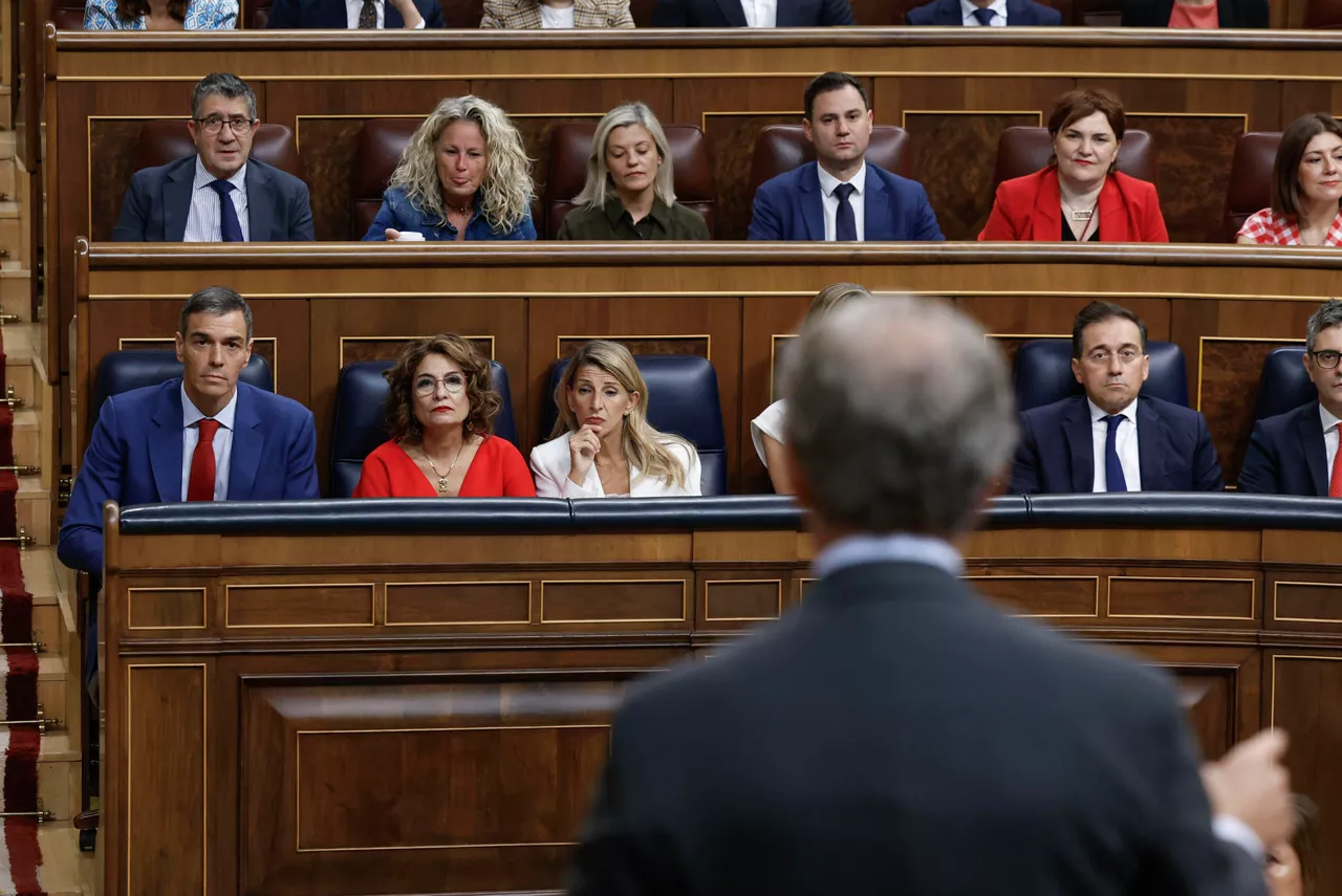 MADRID, 08/10/2025.- El presidente del Gobierno, Pedro Sánchez (i), escucha la intervención del líder del PP, Alberto Núñez Feijóo (de espaldas), durante la sesión de control al gobierno celebrada este miércoles en el Congreso. El Gobierno vuelve a enfrentarse en el Congreso a una jornada difícil en la que quiere sacar adelante su decreto ley para el embargo de armas a Israel y la ley de Movilidad Sostenible, y en ambos casos ya solo depende de Podemos, que mantiene la incógnita sobre el sentido de su voto. EFE/ Chema Moya
