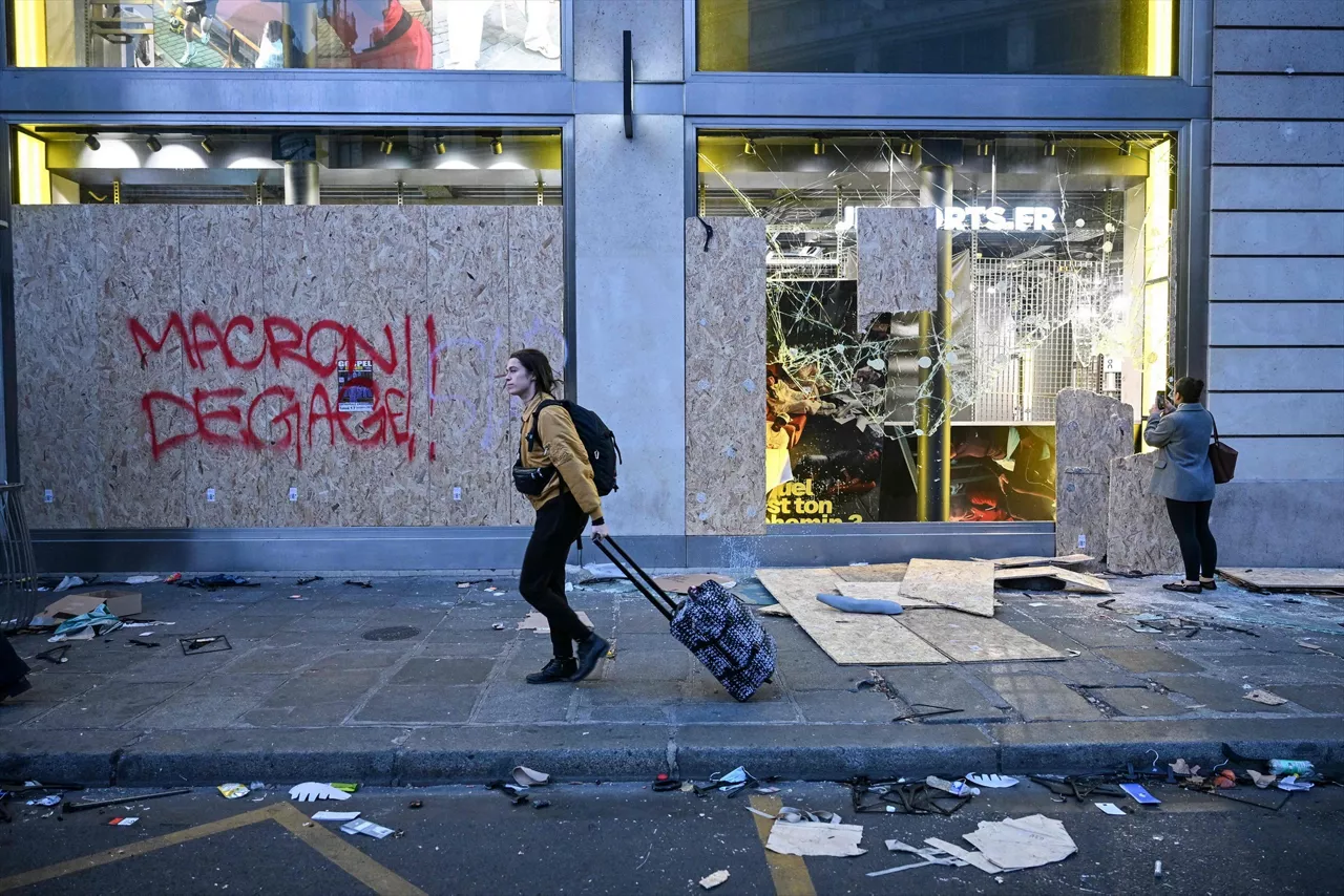 18 October 2026, France, Paris: A pedestrian walks past a damaged shop as another person takes a photograph in Paris, a day after nationwide protests over the rising cost of living. French Prime Minister said 1,200 people were arrested across the country on 17 October, while 150 police officers were injured in clashes with protesters. Photo: Matthieu Rondel/AFP/dpa



18/10/2026 ONLY FOR USE IN SPAIN