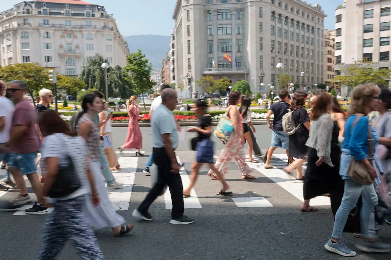 GRAFCAV5116. BILBAO, 19/06/2026.- Ciudadanos cruzan un paso de cebra este viernes en Bilbao. El 52,5 % de los vascos ve necesario priorizar a las personas autóctonas respecto a los inmigrantes en la redistribución de recursos públicos "para que no colapsen" los servicios, según ha evidenciado el último Deustobarómetro Social de la Universidad de Deusto. EFE/Luis Tejido
