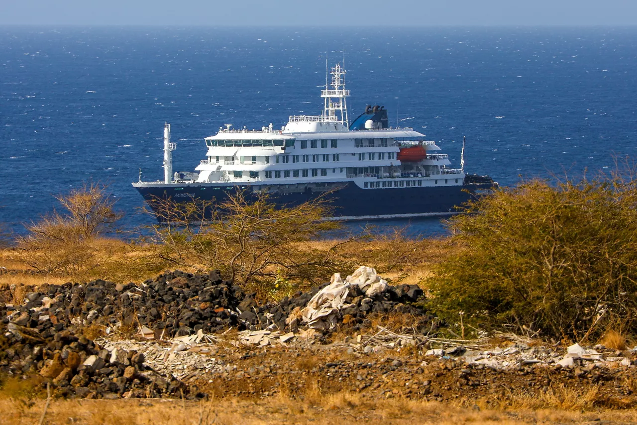 Praia (Cape Verde), 04/05/2026.- Dutch cruise ship MV Hondius (back) is anchored off the coast of the city of Praia on the island of Santiago, Cape Verde, 04 May 2026, after three people died onboard from an acute respiratory syndrome. The World Health Organization (WHO) reported one confirmed case and five additional suspected cases of hantavirus infection on the vessel sailing in the Atlantic Ocean. Three of those affected have died and one is currently in intensive care in South Africa. (Cabo Verde, Sudáfrica) EFE/EPA/ELTON MONTEIRO
