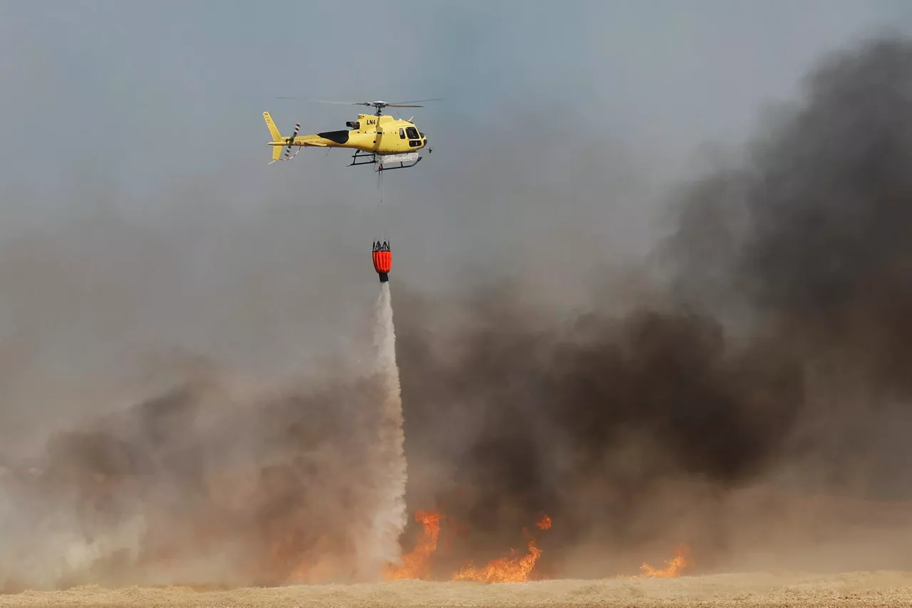 PAMPLONA, 05/07/2026.- Un incendio declarado este domingo en una zona de cereal en Imárcoain, en el término municipal de Noáin (Valle de Elorz), ha obligado a cortar de forma preventiva la autopista AP-15 en ambos sentidos y a interrumpir el suministro eléctrico de la catenaria ferroviaria durante las labores de extinción. En el operativo participan efectivos de los parques de Bomberos de Cordovilla y Tafalla, la Brigada Helitransportada de Incendios Forestales (BHIF), dos helicópteros, dos aviones de carga en tierra del Ministerio para la Transición Ecológica y el Reto Demográfico (MITECO) con base en Agoncillo, guardas forestales, agentes de la Policía Local y de la Policía Foral, además de tractoristas. EFE/ Jesús Diges

