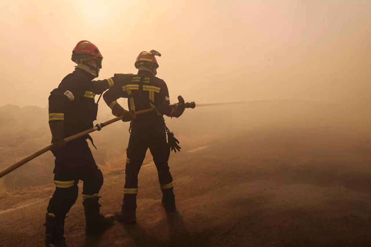 CIPÉREZ (SALAMANCA), 15/08/2025.- Dos bomberos trabajan en la extinción del incendio forestal este viernes, en las proximidades de Cipérez (Salamanca). EFE/JM GARCIA
