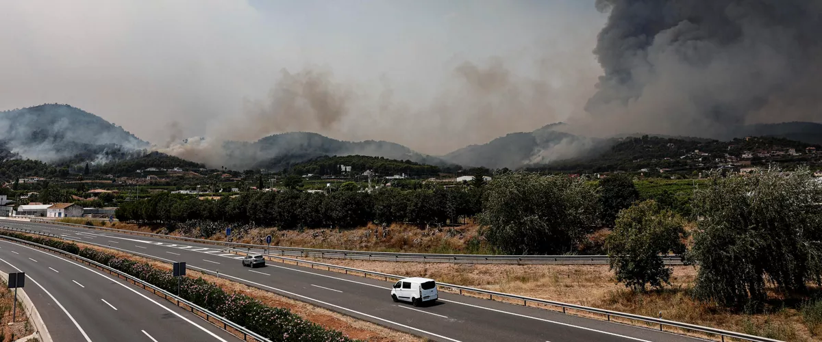 GRAFCVA5195. BETXÍ (CASTELLÓN), 26/07/2026.- Un hidroavión sobrevuela la autovía A-7 tras realizar una descarga de agua en Betxí en el frente del incendio declarado este sábado en la Vall d'Uixó (Castellón), y que ya lleva quemadas unas 4.300 hectáreas y cuyo perímetro supera los 40 kilómetros. EFE/Manuel Bruque
