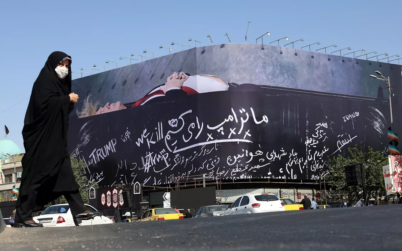 TEHRAN (IRAN(Islamic Republic Of)), 15/07/2026.- A veiled Iranian woman walks next to a huge anti-US billboard featuring US president Donald Trump in a coffin, accompanied by a sentence in Persian that reads: 'We kill Trump' displayed at the Enghelab Square in Tehran, Iran, 15 July 2026. The U.S. military has officially reinstated its naval blockade against Iranian ports and carried out a fourth consecutive day of strikes targeting Tehran's military capabilities, according to U.S. Central Command (CENTCOM). (Teherán) EFE/EPA/ABEDIN TAHERKENAREH RESTRICTIONS: NO Access Israel Media/Persian Language TV Stations Outside Iran/Strictly No Access BBC Persian/VOA Persian/Manoto TV/Iran International TV. (As mandated by Iran's Directorate General for Foreign Media) --
