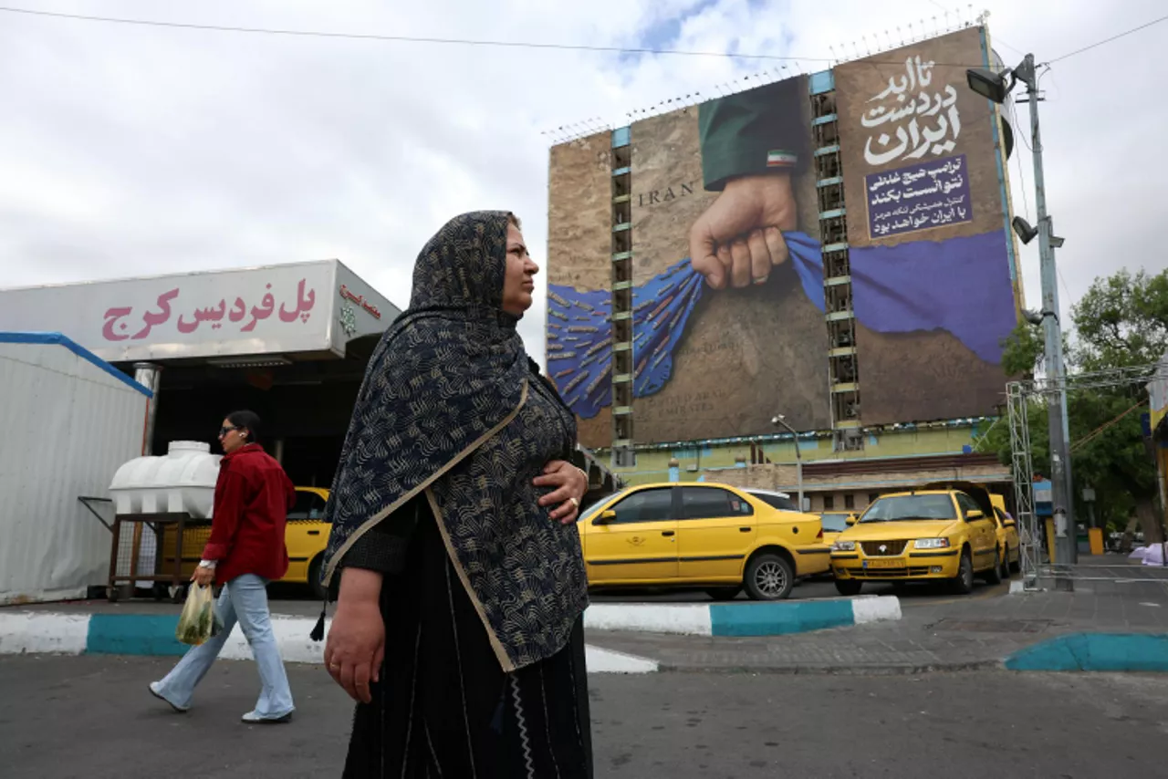 TEHRAN (IRAN(Islamic Republic Of)), 19/04/2026.- Iranians walk past a large-scale billboard referring to the Strait of Hormuz and reading in Persian, “Forever on Iran’s hand,” in a square in Tehran, Iran, 19 April 2026. Tensions between the United States and Iran continue as the Strait of Hormuz remains blocked. (Estados Unidos, Teherán) EFE/EPA/ABEDIN TAHERKENAREH
