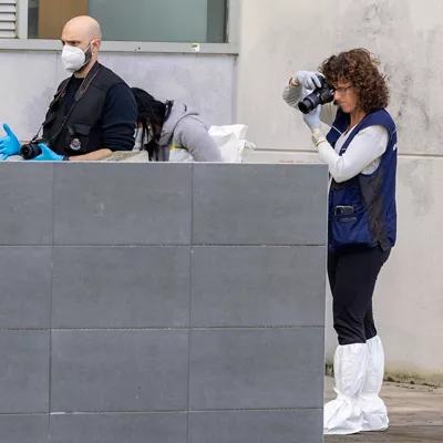 Agentes de la Ertzaintza y una médico forense trabajan en la zona del incendio