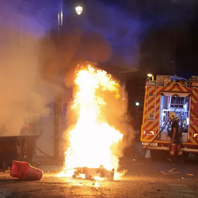BILBAO, 26/10/2026.- Los bomberos extinguen un fuego durante una manifestación de estudiantes y de colectivos 'antifascistas' este lunes por el centro de Bilbao "contra el fascismo" y en protesta por el acto anunciado por el agitador y activista político Vito Quiles para esta tarde en la ciudad. EFE/Luis Tejido
