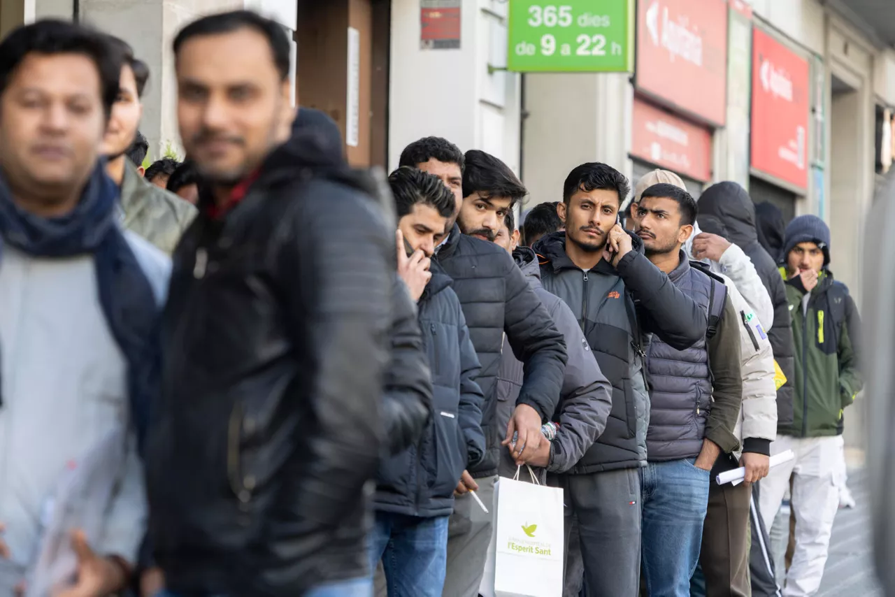 GRAFCAT7440. BARCELONA, 29/01/2026.- El proceso de regularización de inmigrantes aprobado por el Gobierno central ha provocado largas colas en el consulado de Pakistán en Barcelona, a donde numerosas personas acuden para poder disponer de los papeles previos que se requieren para inicio los trámites. EFE/Marta Pérez
