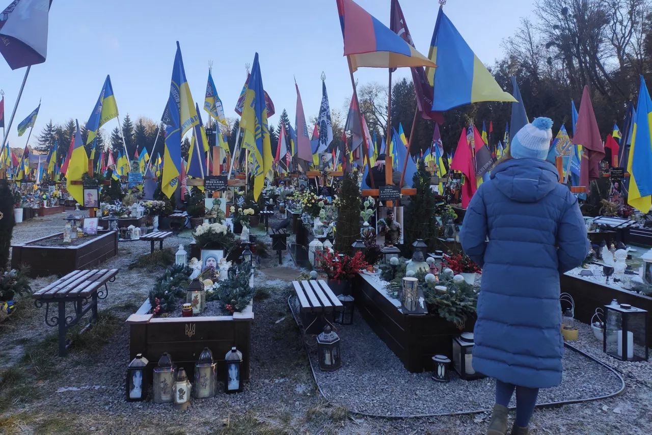 FOTODELDIA LEÓPOLIS (UCRANIA), 25/12/2025.- Muchas familias acuden a las tumbas de sus seres queridos, caídos en la Guerra contra Rusia, para pasar un tiempo juntos en Navidad y dejar regalos simbólicos este jueves, en Leópolis (Ucrania). Ucrania celebró este jueves su cuarta Navidad en guerra entre ataques rusos y con escasas esperanzas de paz, mientras aguardaba la respuesta oficial de Moscú al plan de 20 puntos para poner fin al conflicto elaborado por Kiev y Washington. Muchas familias, que incluían a soldados de permiso o en rehabilitación, paseaban el día de hoy por las calles de Leópolis (oeste) y de otras ciudades ucranianas, en un intento de absorber al menos un poco de espíritu navideño. EFE/ Rostyslav Averchuk
