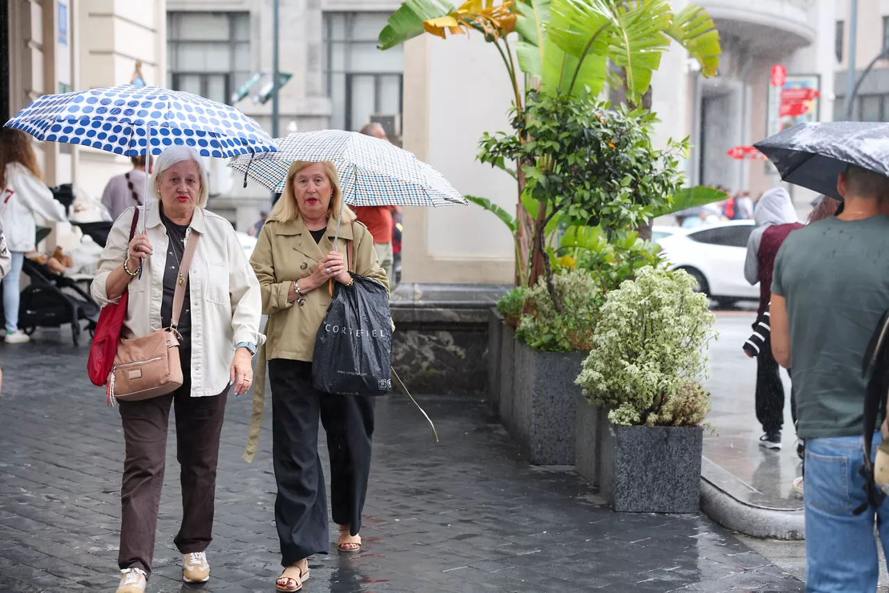 GRAFCAV1057. BILBAO, 28/07/2025.-Dos mujeres se protegen del agua con paraguas este lunes en Bilbao. La Agencia Estatal de Meteorología (Aemet) da cuenta para este lunes la presencia de una circulación atlántica que afectará al nordeste peninsular y Baleares, con abundante nubosidad y precipitaciones desplazándose por el Cantábrico, alto Ebro, Pirineos, este de Cataluña y Baleares.EFE/Luis Tejido
