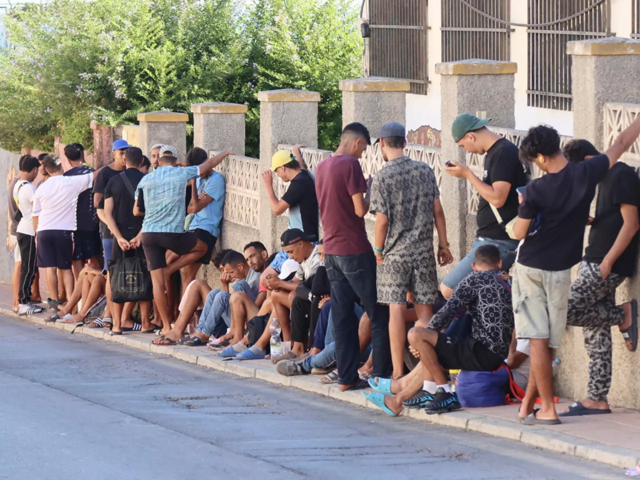 CEUTA, 22/08/2026.- Varios migrantes que no han sido alojados charlan este sábado en una calle de Ceuta. EFE/ Reduan
