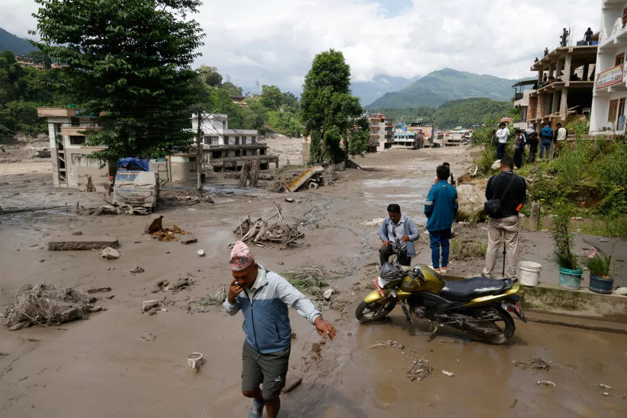 Trishuli Bazar (Nepal), 26/08/2026.- Villagers wade through flooded streets following a flash flood in Trishuli Bazar, Nuwakot district, Nepal, 26 August 2026. Several people were killed and multiple others were reported missing after a massive flash flood swept through Rasuwa and Nuwakot districts causing widespread destruction to settlements and infrastructure, according to local authorities. (Inundaciones) EFE/EPA/NARENDRA SHRESTHA

