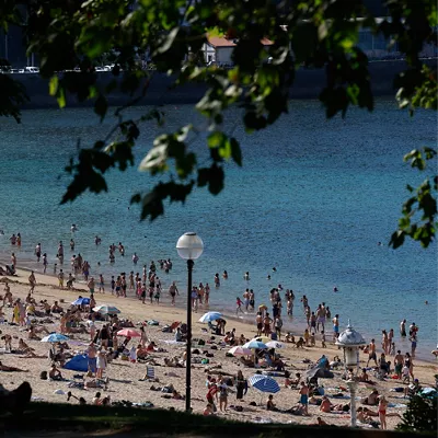 GRAFCAV3938. SAN SEBASTIÁN (ESPAÑA), 25/05/2026.- Un hombre observa desde la sombra la playa de Ondarreta de San Sebastián. El episodio de calor sofocante que sacude al país se disparará aún más esta semana con un repunte de temperaturas a partir del miércoles en la mayor parte de la península: donde habrá noches "tropicales en muchos puntos", con mínimas que no bajarán de 20 grados. EFE/Juan Herrero
