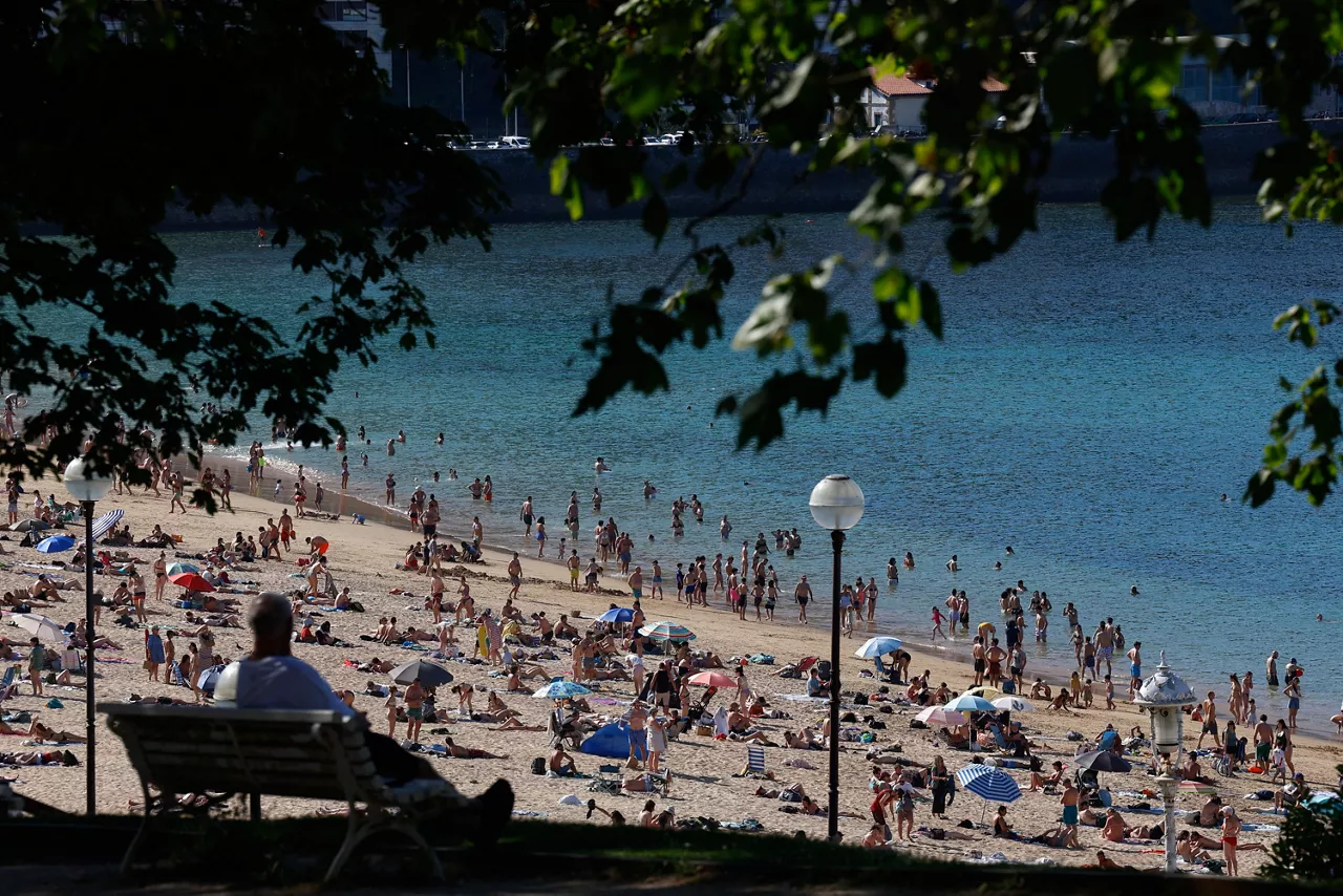 GRAFCAV3938. SAN SEBASTIÁN (ESPAÑA), 25/05/2026.- Un hombre observa desde la sombra la playa de Ondarreta de San Sebastián. El episodio de calor sofocante que sacude al país se disparará aún más esta semana con un repunte de temperaturas a partir del miércoles en la mayor parte de la península: donde habrá noches "tropicales en muchos puntos", con mínimas que no bajarán de 20 grados. EFE/Juan Herrero
