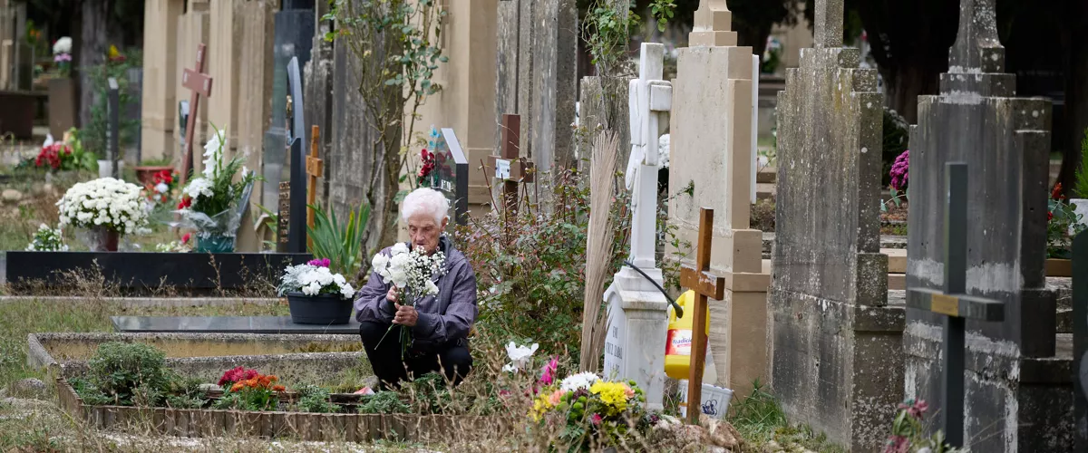 A woman visits the tomb of a beloved one at the cemetery of the town of Pamplona during All Saints Day, in Navarra, northern Spain, 01 November 2025. Spaniards visit cemeteries to remember their late relatives bringing them flowers and cleaning their tombs. EFE/ Inaki Porto
