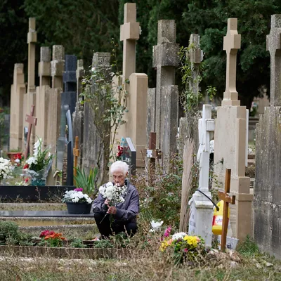 A woman visits the tomb of a beloved one at the cemetery of the town of Pamplona during All Saints Day, in Navarra, northern Spain, 01 November 2025. Spaniards visit cemeteries to remember their late relatives bringing them flowers and cleaning their tombs. EFE/ Inaki Porto
