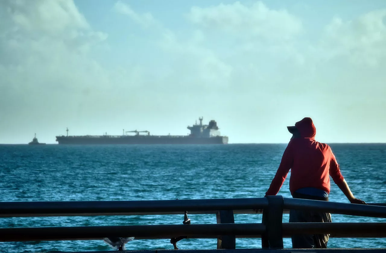 AME9151. MATANZAS (CUBA), 31/03/2026.- Una persona observa la entrada del buque petrolero ruso Anatoli Kolodkin este martes, en la bahía de Matanzas (Cuba). La embarcación, que pertenece a la corporación Sovkomflot sancionada por EE. UU. desde 2024 y que partió del puerto ruso de Primorsk el pasado 9 de marzo, es el primer cargamento de petróleo en llegar a la isla en los últimos tres meses. EFE/STR
