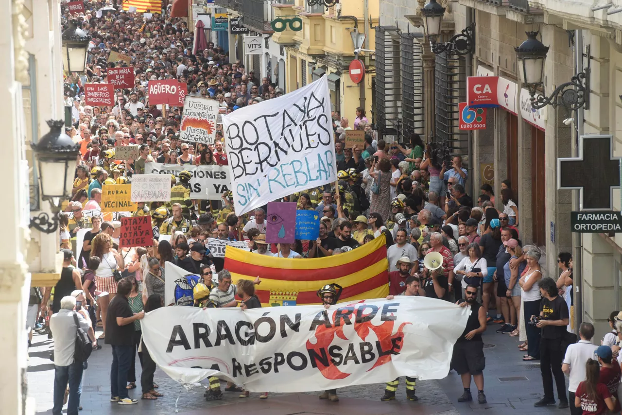 JACA, 23/08/2026.- Una manifestación convocada por el Movimiento Por la Dignidad de la Montaña pide este domingo en Jaca (Huesca) la dimisión del presidente del Gobierno de Aragón, Jorge Azcón, y el vicepresidente, Alejandro Nolasco, a los que este colectivo considera "principales responsables políticos" del incendio forestal de Las Peñas de Riglos, que ha quemado unas 14.500 hectáreas. EFE/ Javier Blasco
