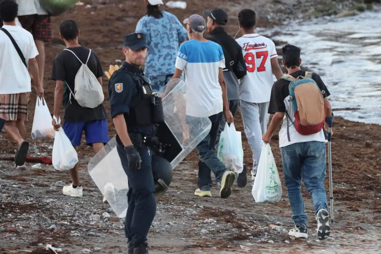 CEUTA, 28/08/2026.- La Policía Nacional desaloja de las inmediaciones de la playa del Trampolín a los migrantes para evitar posibles incidentes con los manifestantes que protestan ante la crisis de inmigración, este viernes en Ceuta. EFE/Reduan
