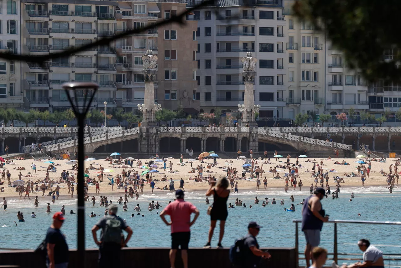 Bañistas disfrutan de un día veraniego en la bahía de la Concha de San Sebastián. La ola de calor que está afectando a Euskadi desde hace días podría haber ocasionado la muerte de catorce personas, según el Sistema de Monitorización de Mortalidad Diaria (Momo) del Instituto de Salud Carlos III. EFE/Juan Herrero
