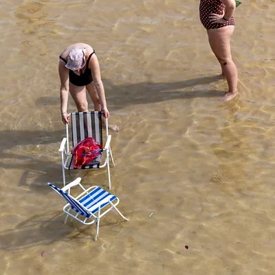 SAN SEBASTIÁN, 20/06/2026.- Dos mujeres se refrescan este sábado en la orilla de la playa de La Concha de San Sebastián. Los cielos en Euskadi se presentan este domingo con escasa nubosidad para recibir la temporada estival con calor de pleno verano y temperaturas que superarán los 35 grados en los tres territorios, y los 40º en algunos puntos.EFE/Javier Etxezarreta
