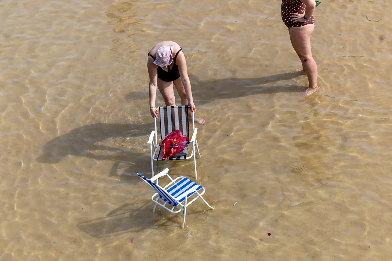 SAN SEBASTIÁN, 20/06/2026.- Dos mujeres se refrescan este sábado en la orilla de la playa de La Concha de San Sebastián. Los cielos en Euskadi se presentan este domingo con escasa nubosidad para recibir la temporada estival con calor de pleno verano y temperaturas que superarán los 35 grados en los tres territorios, y los 40º en algunos puntos.EFE/Javier Etxezarreta
