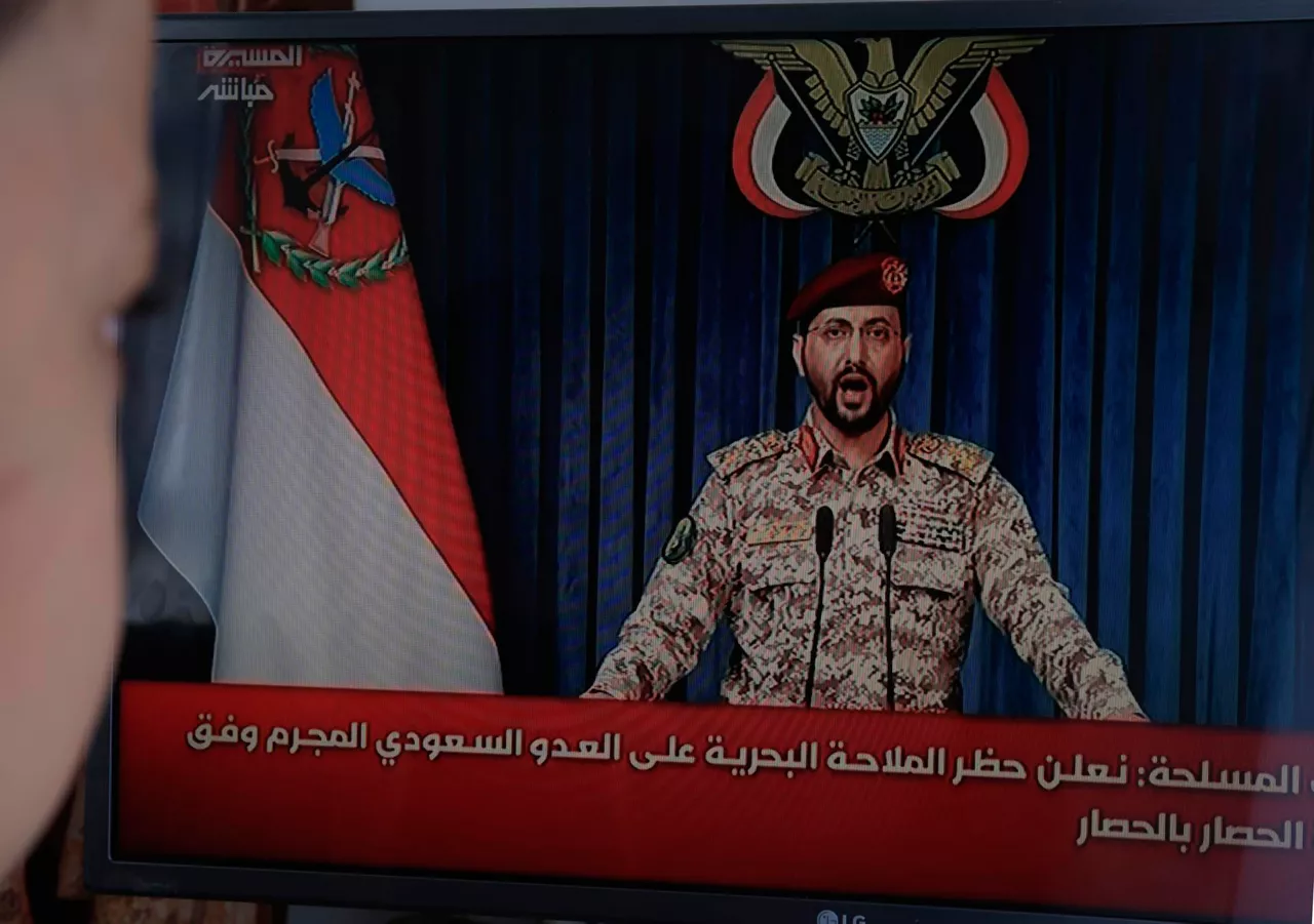 SANA'A (Yemen), 20/07/2026.- A person watches Houthi military spokesman Yahya Sarea deliver a televised statement in Sana'a, Yemen, 20 July 2026. Yemen's Houthis announced a maritime embargo against Saudi Arabia amid escalating tensions following the bombing of Sana'a airport on 13 July, according to a statement by Houthi military spokesman Yahya Sarea. (Arabia Saudita) EFE/EPA/YAHYA ARHAB
