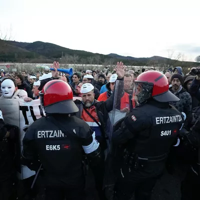 MURRIO (ÁLAVA), 09/02/2026.- Trabajadores tras un cordón de la Ertzaintza durante una manifestación convocada en el acceso a la fábrica de Tubos Reunidos en la localidad alavesa de Murrio, este lunes, tras el inicio anoche de una huelga convocada a la espera de conocer el número de afectados por el ERE. EFE/ Adrián Ruiz Hierro
