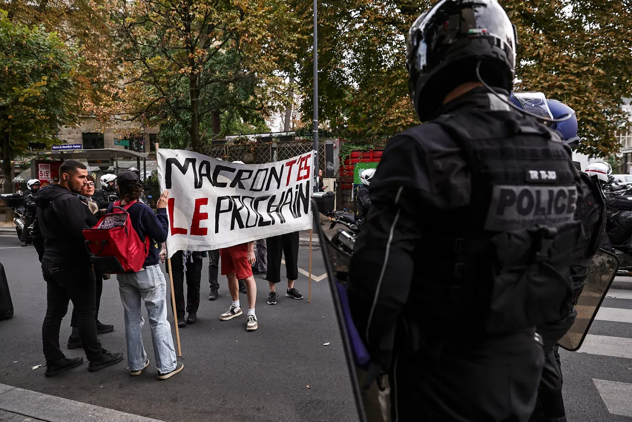 Paris (France), 08/09/2025.- Police officers block a group of people carrying a banner reading 'Macron, you're next' during a spontaneous rally following the rejection of the vote of confidence requested for Prime Minister François Bayou, in Montreuil, Paris, France, 08 September 2025. French Prime Minister Francois Bayrou has lost the vote of confidence after he activated Article 49.1 of the Constitution. (Francia) EFE/EPA/TERESA SUAREZ
