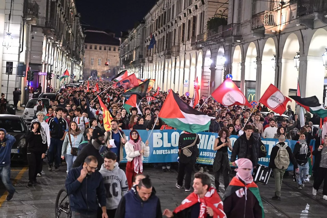 TURIN (Italy), 01/10/2025.- People take part in a protest in support of the Palestinian people and the Global Sumud Flotilla (GSF) after the Israeli navy has begun to intercept boats from the GSF, in Turin, Italy, 01 October 2025. The Global Sumud Flotilla, an international maritime initiative that began sailing in August 2025 en route to the Gaza Strip, aims to break the Israeli blockade and deliver humanitarian aid to Gaza. (Protestas, Italia) EFE/EPA/ALESSANDRO DI MARCO
