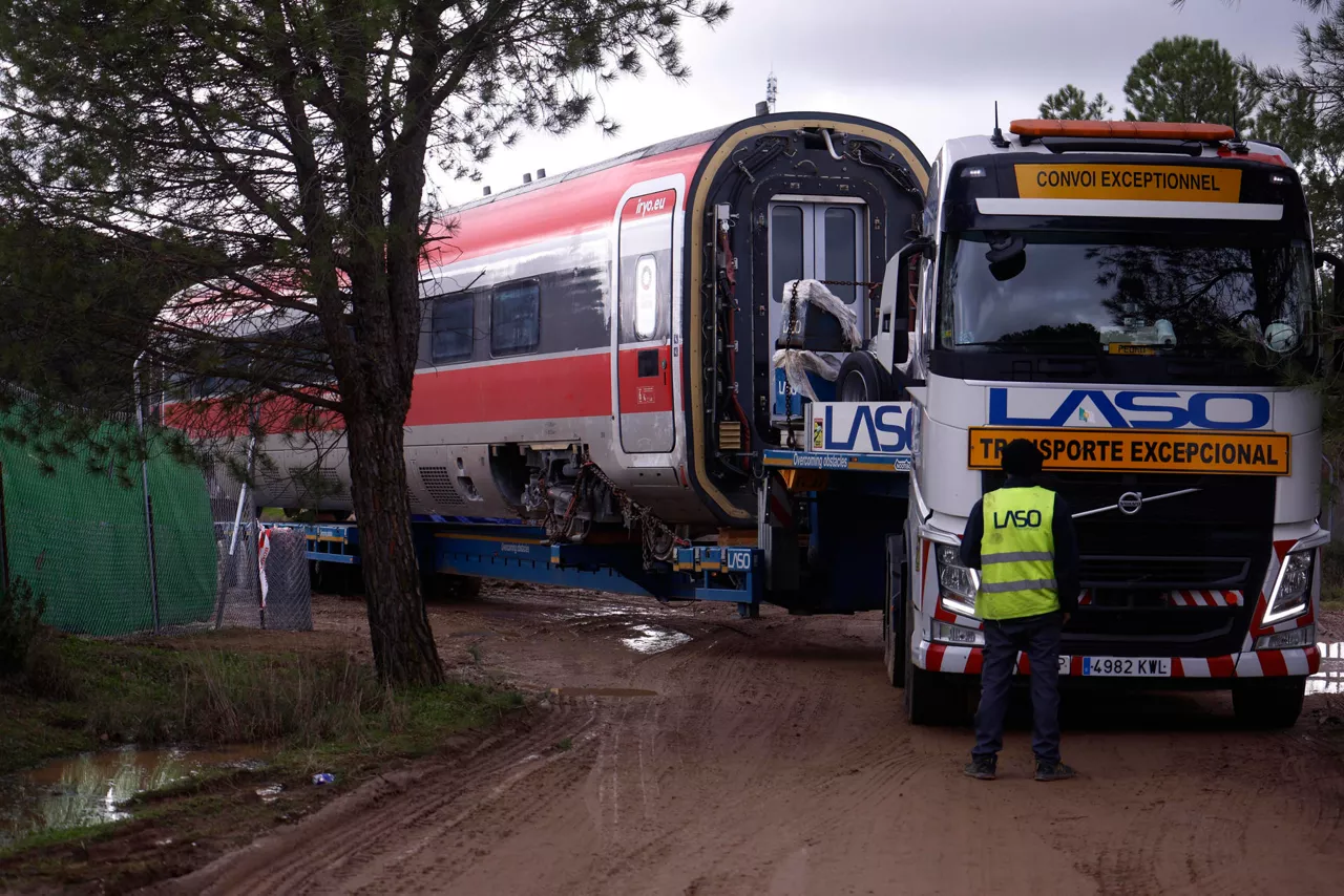 ADAMUZ (CÓRDOBA), 24/01/2026.- Trabajos de retirada de las vías de los vagones del Iryo, este sábado en Adamuz (Córdoba). Los cinco vagones de este tren que no se salieron de los carriles en el accidente del pasado domingo se están trasladandopor la vía de alta velocidad en dirección a Madrid. Los otros tres vagones, a partir del sexto, se encuentran en las inmediaciones de la vía, retirados ya de la misma, a la espera de ser trasladados de otras formas. El accidente causó 45 muertos y más de cien heridos. EFE/Salas

