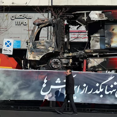 TEHRAN (IRAN(Islamic Republic Of)), 16/01/2026.- An Iranian man walks next to the wreckage of a fire fighter vehicle that burned during anti‑government protests in a street in Tehran, Iran, 16 January 2026. The country remains under a near-total nationwide internet blackout that began on 08 January, amid an intensifying wave of anti-government protests. (Protestas, Teherán) EFE/EPA/ABEDIN TAHERKENAREH
