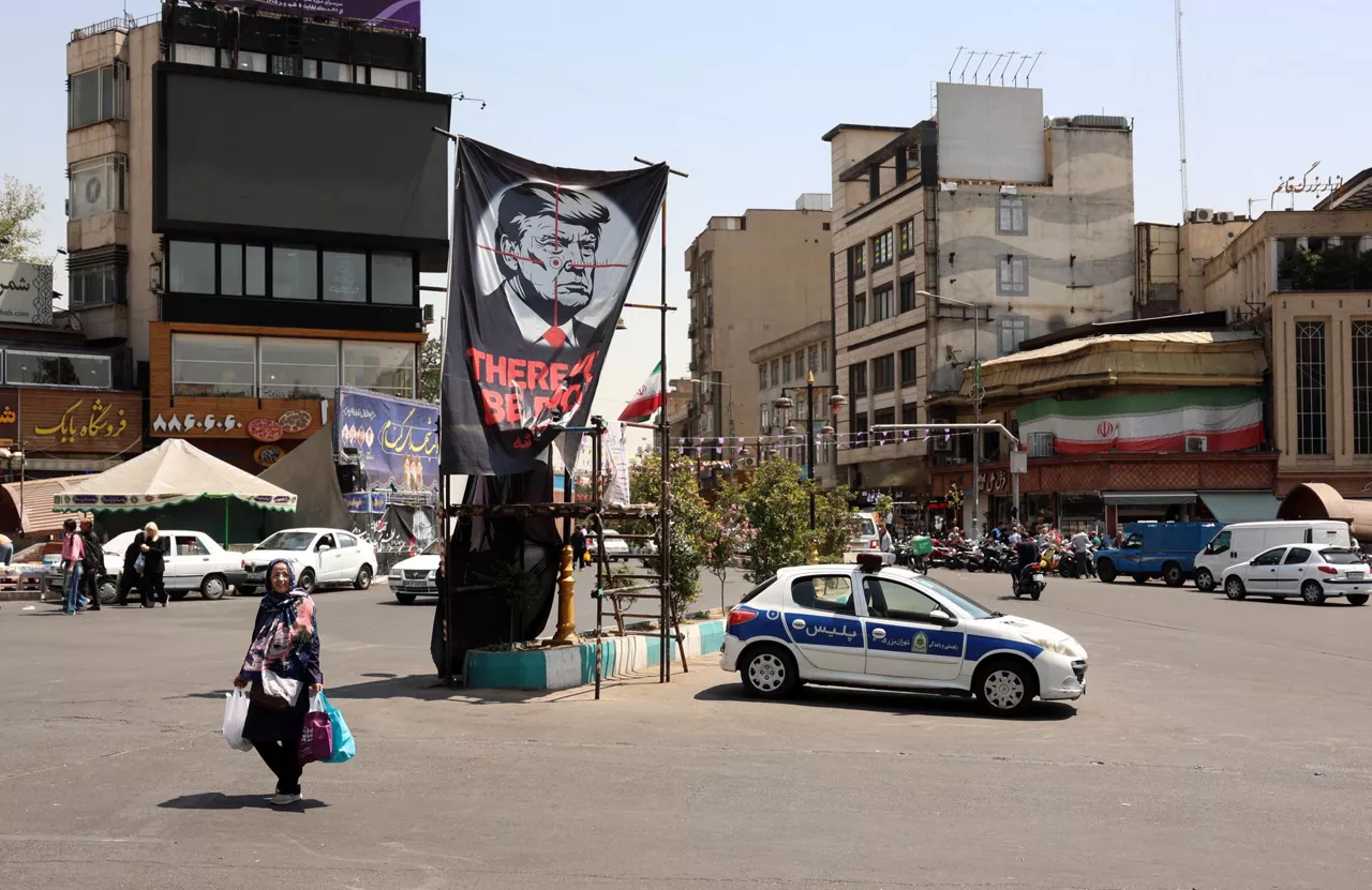 TEHRAN (IRAN(Islamic Republic Of)), 25/08/2026.- An Iranian woman walks with her shopping bags next to an anti-US banner depicting US President Donald Trump in northern Tehran, Iran, 25 August 2026. US Treasury Secretary Scott Bessent announced, at President Donald Trump's direction, the launch of 'Operation Economic Outcast,' an economic campaign targeting Iran and its financial connections. (Teherán) EFE/EPA/ABEDIN TAHERKENAREH RESTRICTIONS: NO Access Israel Media/Persian Language TV Stations Outside Iran/Strictly No Access BBC Persian/VOA Persian/Manoto TV/Iran International TV. (As mandated by Iran's Directorate General for Foreign Media) --
