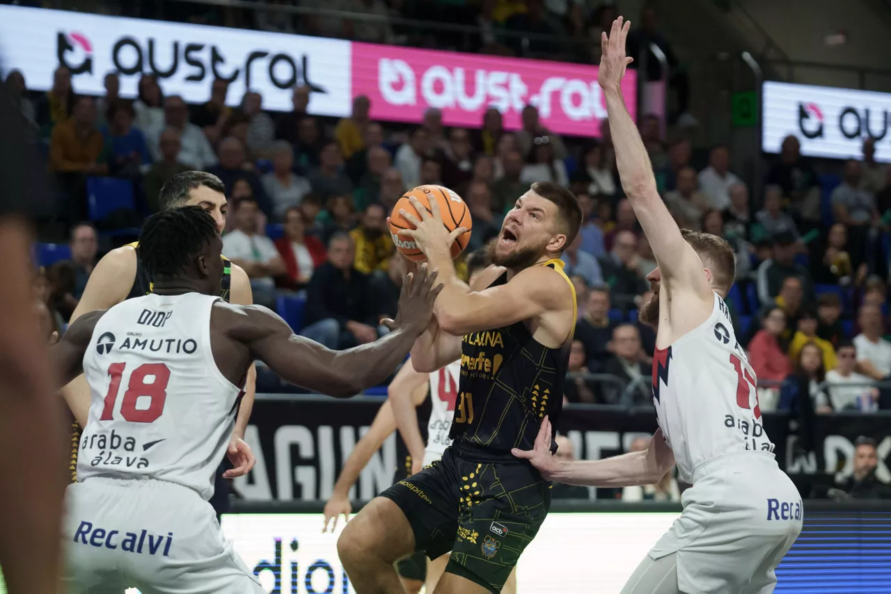 LA LAGUNA (TENERIFE), 01/02/2026.- El alero del La Laguna Tenerife Rokas Giedraitis (c) entra a canasta durante el partido correspondiente a la liga Endesa que se celebra este domingo en el Pabellón Santiago Martín de La Laguna (Tenerife) que enfrenta al La Laguna Tenerife y al Kosner Baskonia. EFE/ Ramón De La Rocha

