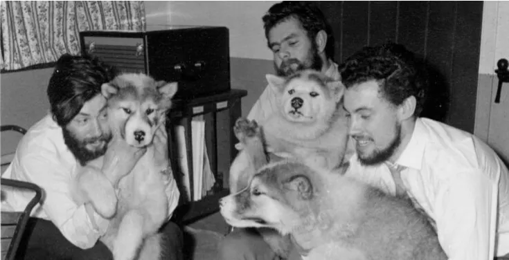 Dennis Bell (left) with colleagues and dogs who helped them work in Antarctica in the middle of the winter of 1959 at Admiralty Bay Base. Photo: British Antartic Survey.