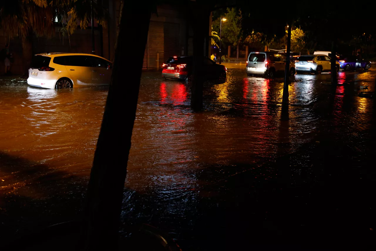 GRAF8395. VALENCIA, 16/09/2026.- Coches circulan por una calle inundada tras las fuertes lluvias caídas en Valencia, este miércoles. Los bomberos del Consorcio Provincial de Valencia han llevado ya a cabo, desde las ocho de la tarde, unos 25 servicios relacionados con las lluvias y tormentas que recorren València y su área metropolitana, hasta el momento sin incidentes graves. EFE/ Ana Escobar
