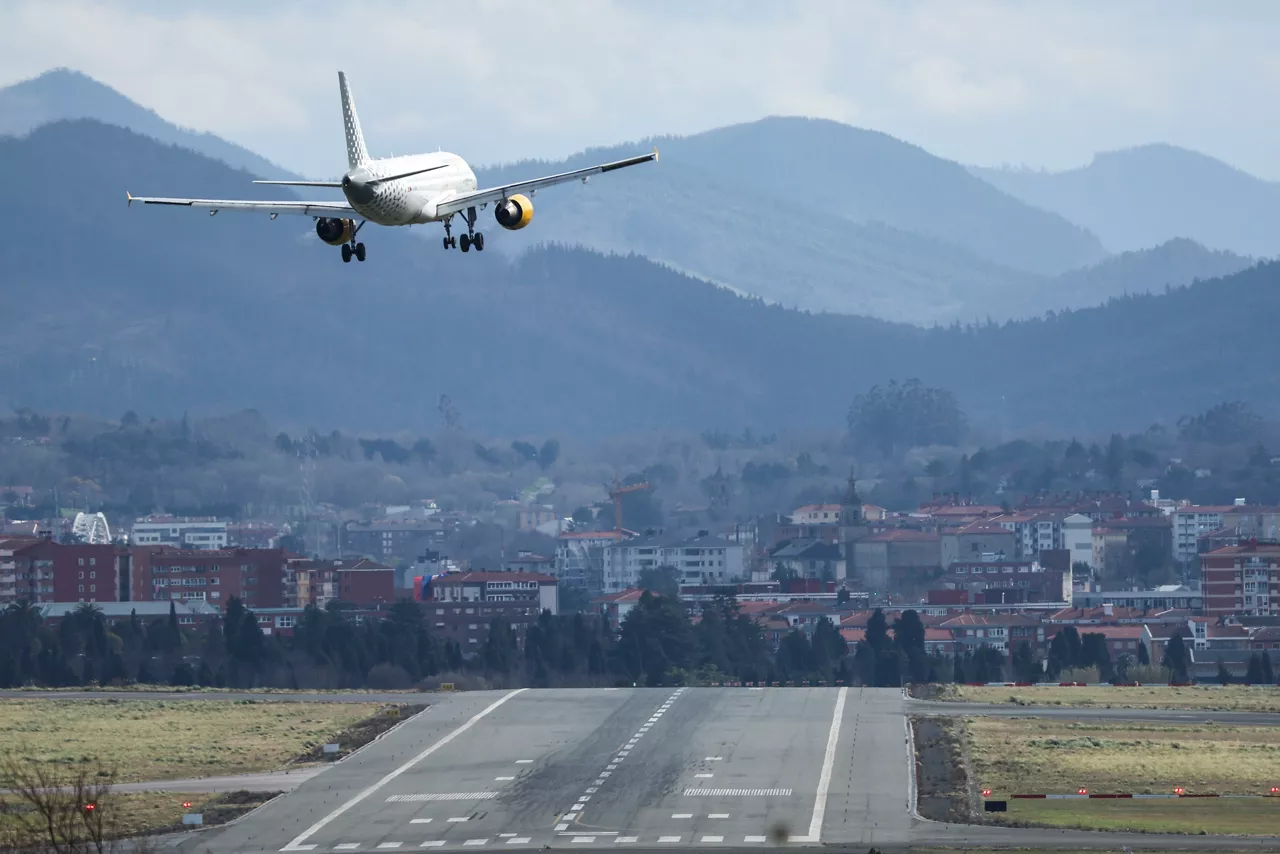 GRAFCAV9987. BILBAO, 18/02/2026.-Un avión en la maniobra de aproximación ante fuertes rachas de viento en la pista de rodadura del aeropuerto de Bilbao. Pedro, la decimosexta borrasca de la temporada, trae este miércoles nuevas precipitaciones, vientos muy fuertes, temporal marítimo y nevadas a 900 metros, situación que se prolongará el jueves, antes de que el viernes se imponga el tiempo anticiclónico y el fin de semana permita disfrutar de "un anticipo de la primavera", según la Aemet. EFE/Luis Tejido
