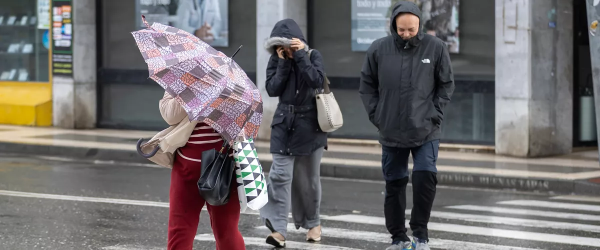 HUELVA, 07/02/2026.- Una mujer se protege del viento y la lluvia este sábado en Huelva. El fuerte temporal de lluvia y nieve que afecta a España ha provocado el corte de 168 carreteras, más del 80 por ciento en la región de Andalucía (sur), donde las inundaciones han causado cuantiosos daños materiales en infraestructuras y explotaciones agropecuarias y han obligado a desalojar a 11.000 personas de varias localidades. EFE/Alberto Díaz
