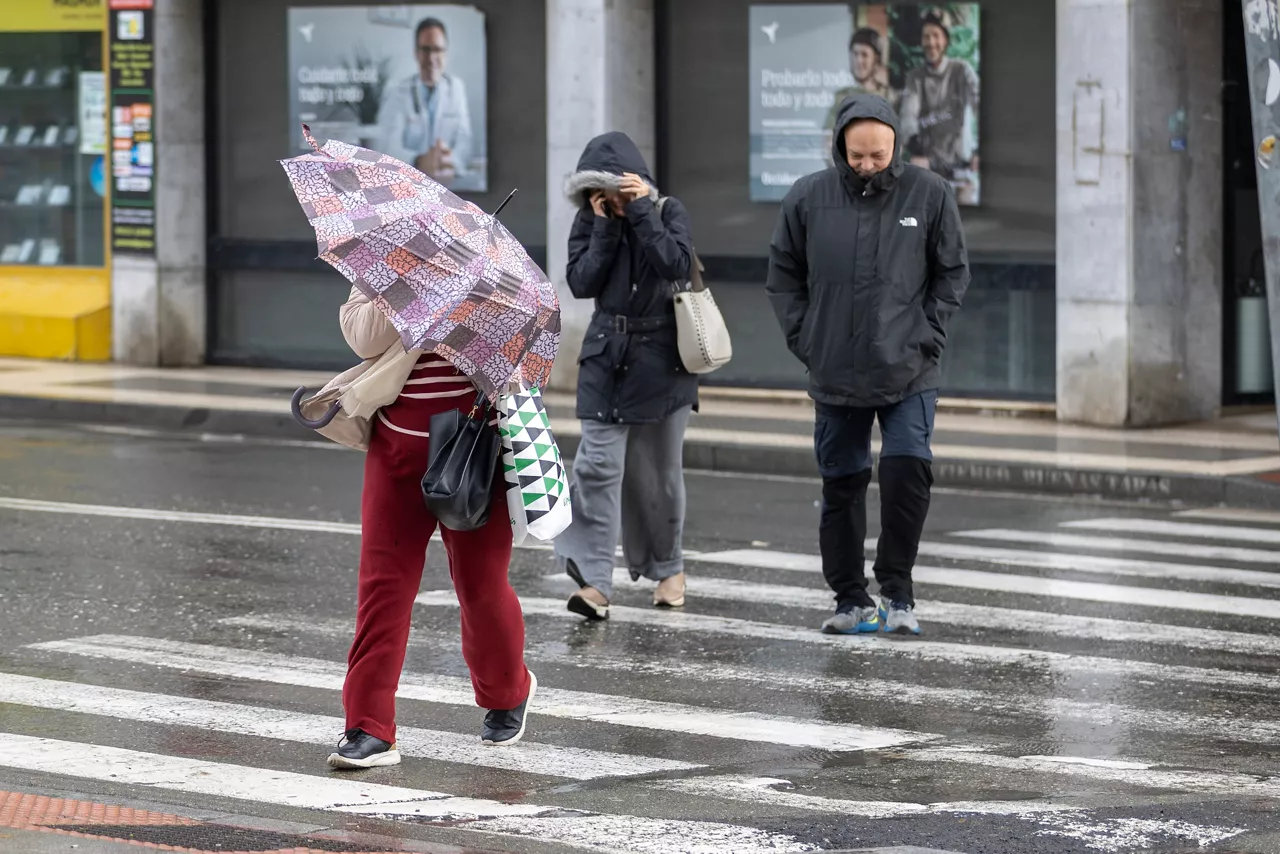 HUELVA, 07/02/2026.- Una mujer se protege del viento y la lluvia este sábado en Huelva. El fuerte temporal de lluvia y nieve que afecta a España ha provocado el corte de 168 carreteras, más del 80 por ciento en la región de Andalucía (sur), donde las inundaciones han causado cuantiosos daños materiales en infraestructuras y explotaciones agropecuarias y han obligado a desalojar a 11.000 personas de varias localidades. EFE/Alberto Díaz
