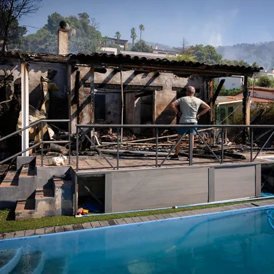 FOTODELDIA CALONGE (GIRONA), 04/07/2026.- Un hombre contempla los restos de una vivienda calcinada en la localidad de Calonge este sábado tras el incendio forestal que comenzó ayer en La Bisbal de l'Empordà (Girona). EFE/David Borrat
