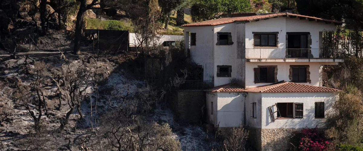 CALONGE (GIRONA), 05/07/2026.- Vivienda alcanzada por el incendio en la localidad de Calonge (Girona), este domingo. Protección Civil ha levantado las órdenes de confinamiento en los siete municipios afectados por el incendio que se desató el pasado viernes en La Bisbal d'Empordà (Girona) y permite regresar a sus casas a los vecinos de las localidades gerundenses de Santa Cristina d'Aro y Calonge i Sant Antoni evacuados por la proximidad de las llamas. EFE/David Borrat.
