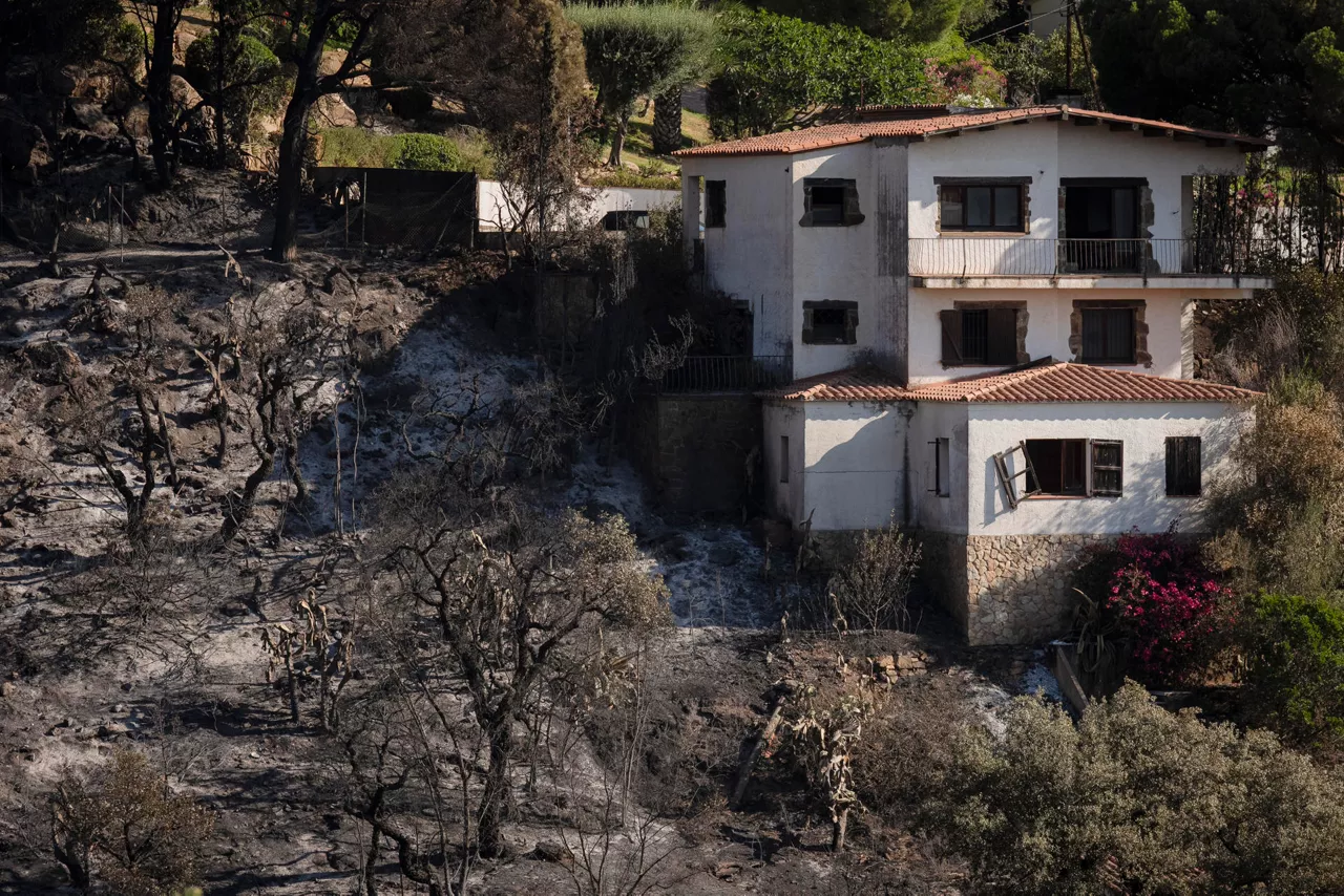 CALONGE (GIRONA), 05/07/2026.- Vivienda alcanzada por el incendio en la localidad de Calonge (Girona), este domingo. Protección Civil ha levantado las órdenes de confinamiento en los siete municipios afectados por el incendio que se desató el pasado viernes en La Bisbal d'Empordà (Girona) y permite regresar a sus casas a los vecinos de las localidades gerundenses de Santa Cristina d'Aro y Calonge i Sant Antoni evacuados por la proximidad de las llamas. EFE/David Borrat.
